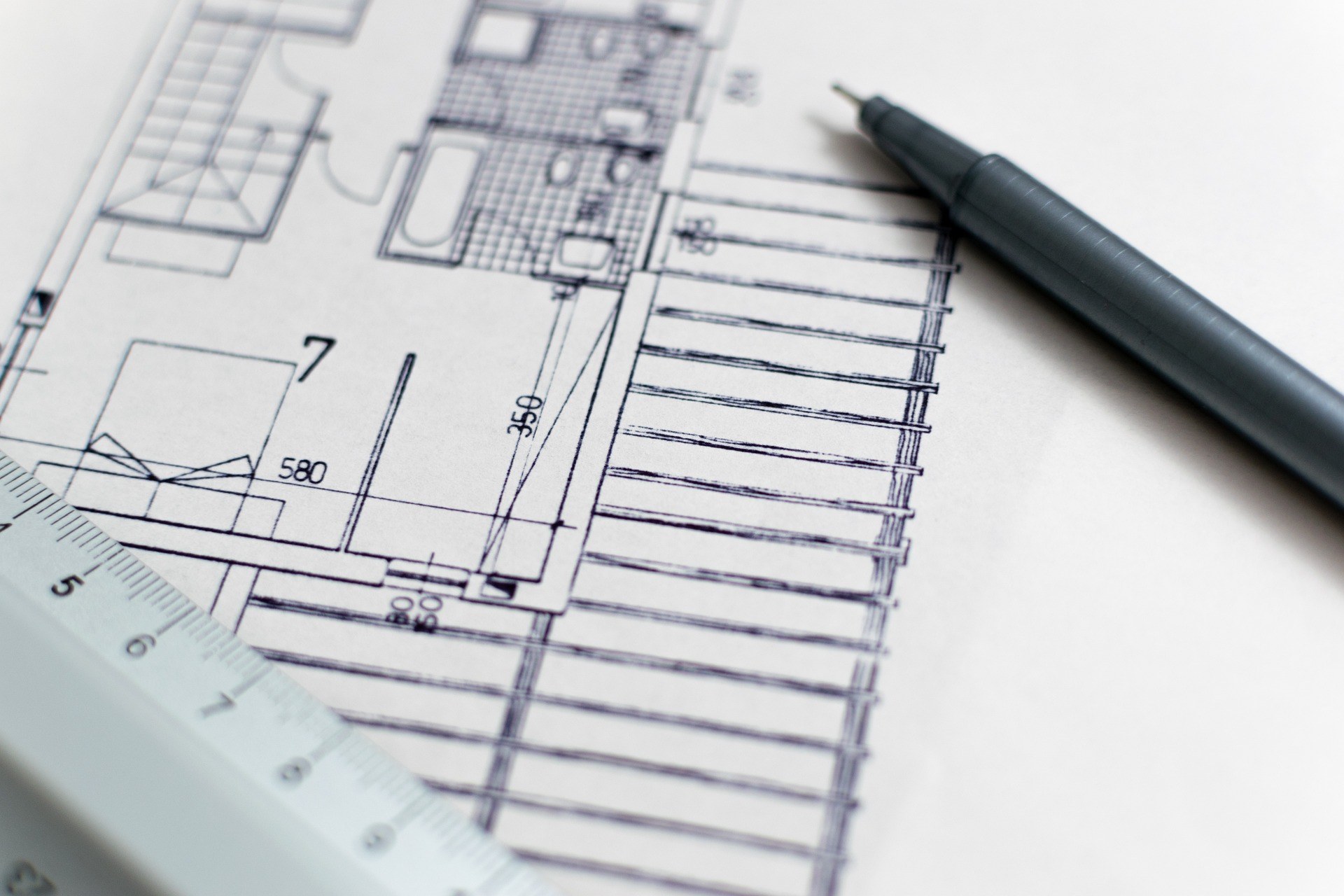 Close-up of an architectural blueprint with a ruler and pen